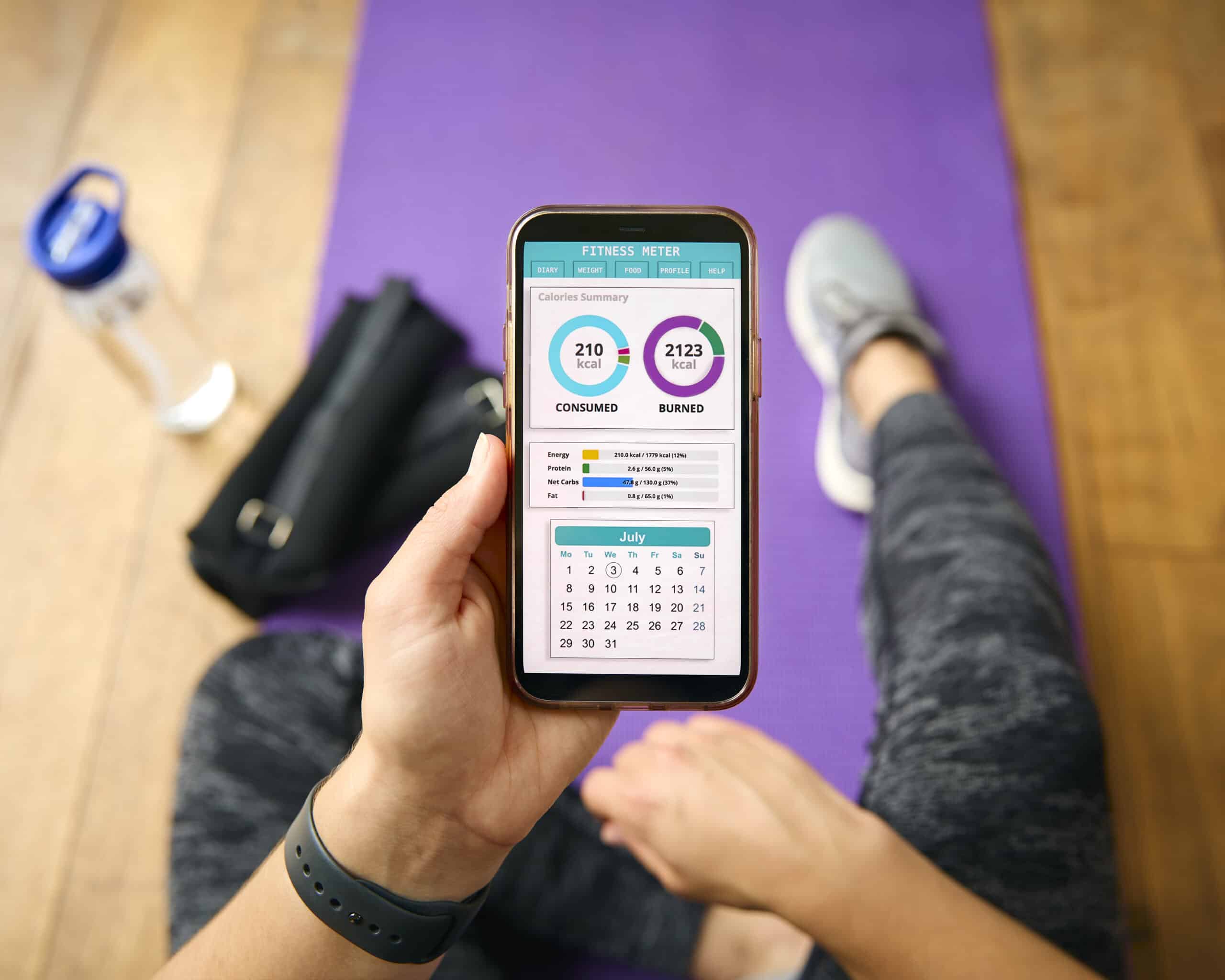 Person reviewing wellness and fitness metrics on a smartphone as part of preparing for a bioresonance scan and overall wellness journey.