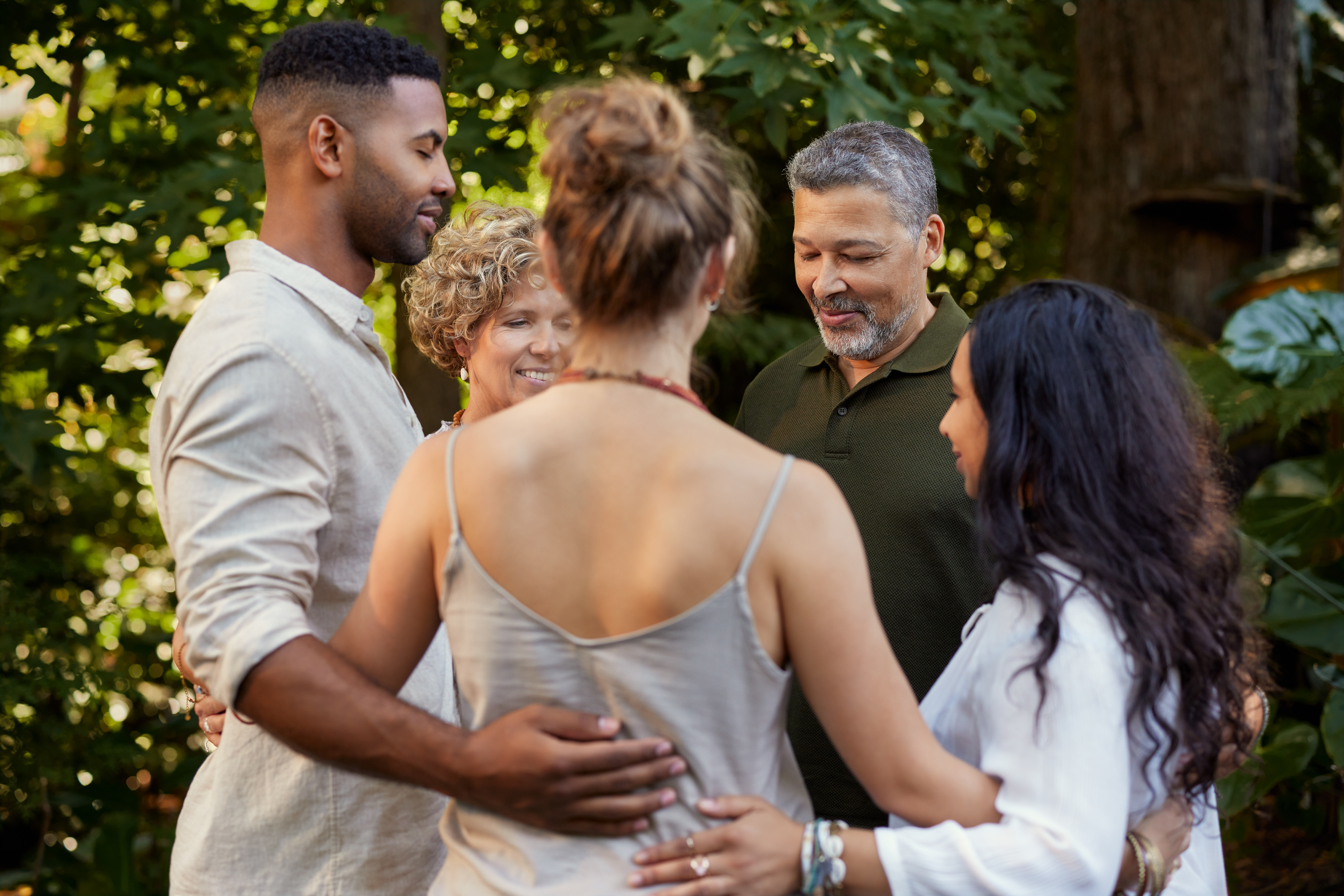 A group standing together in a circle outdoors, symbolizing community, holistic wellness practitioners, and whole-person support.